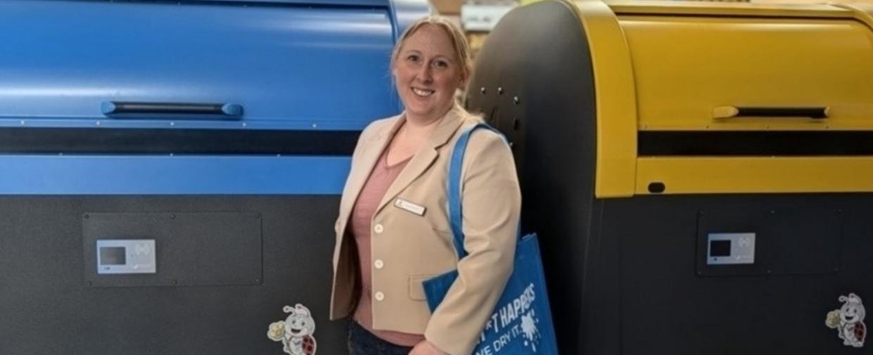 Jana Fisenko auf einer Fachmesse zwischen zwei Anlagen